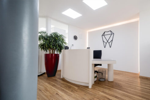 Ansicht Rezeption, im Hintergrund 3D Logo an der weißen Wand